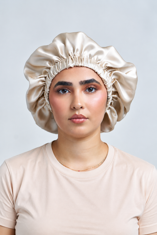 Femme portant le bonnet élastique en soie de mûrier doublé champagne, taille XL, vue de face – MYSILK